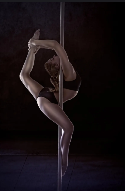 Pole dancer demonstrating strength and peak performance